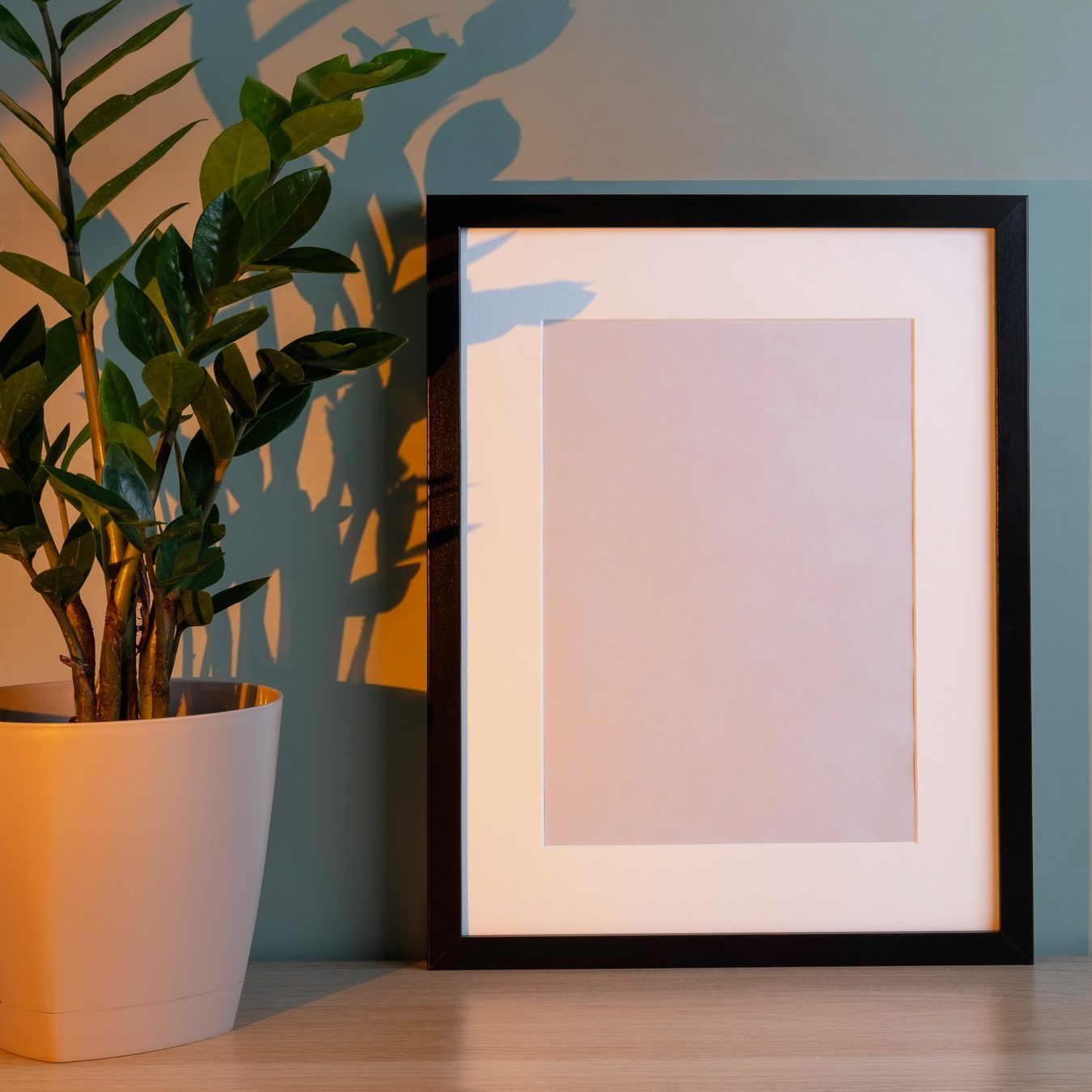 Blank frame mockup for artwork or print on green wall background.