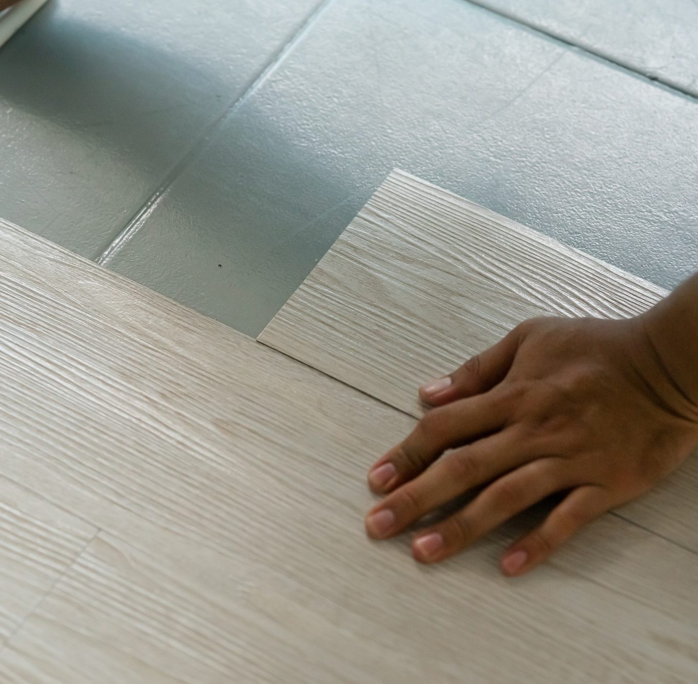 hand installing vinyl flooring